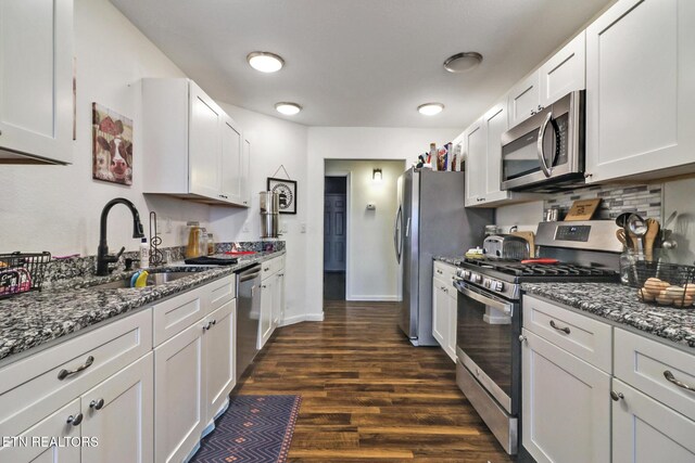 kitchen featuring stone countertops, stainless steel appliances, dark wood-style floors, and white cabinets