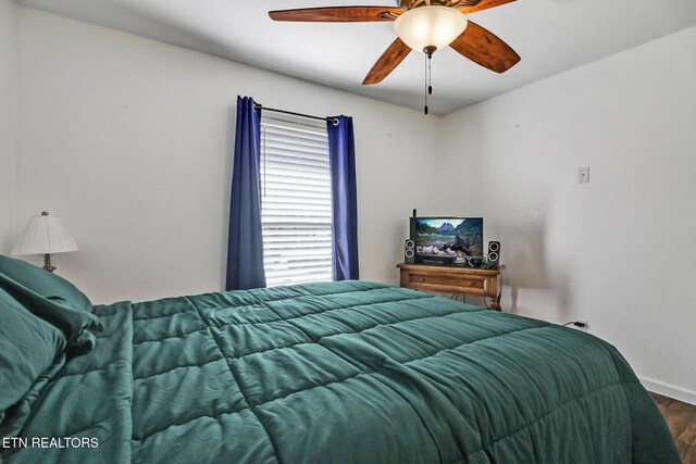 bedroom with ceiling fan, baseboards, and wood finished floors