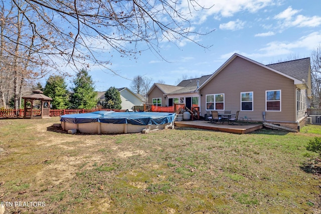 exterior space with a gazebo, a fenced in pool, a lawn, and a deck