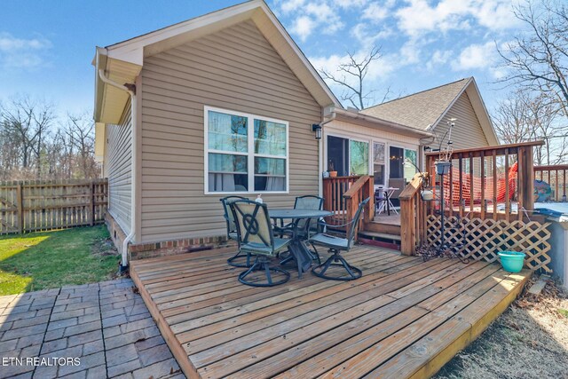 wooden deck with outdoor dining area and fence