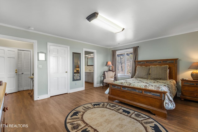 bedroom featuring ornamental molding, ensuite bathroom, baseboards, and wood finished floors