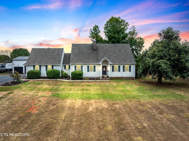 view of front of house featuring a chimney, a detached garage, roof with shingles, crawl space, and a front yard