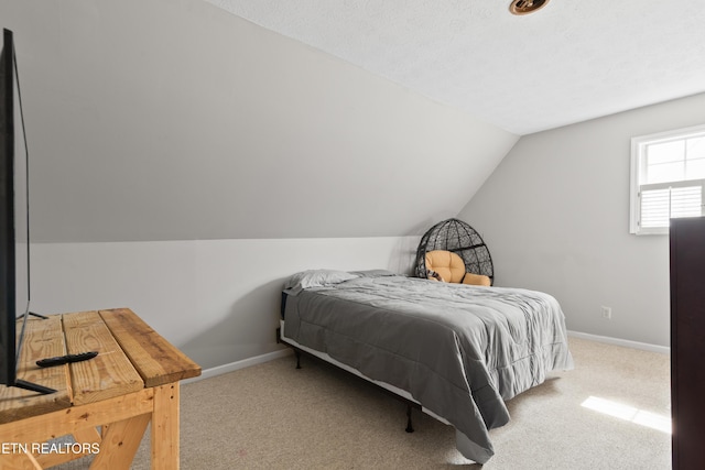 carpeted bedroom with vaulted ceiling and baseboards