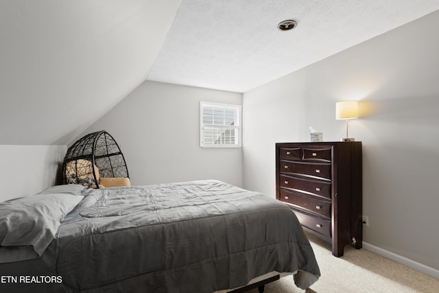 bedroom with lofted ceiling, baseboards, and light colored carpet