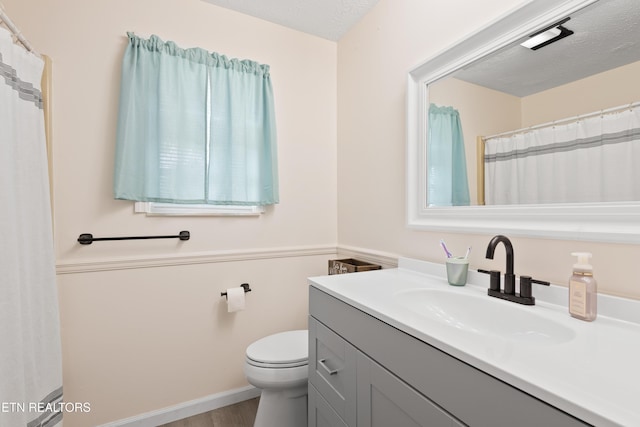 bathroom featuring toilet, a textured ceiling, wood finished floors, and vanity