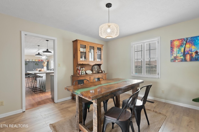 dining area featuring light wood finished floors and baseboards