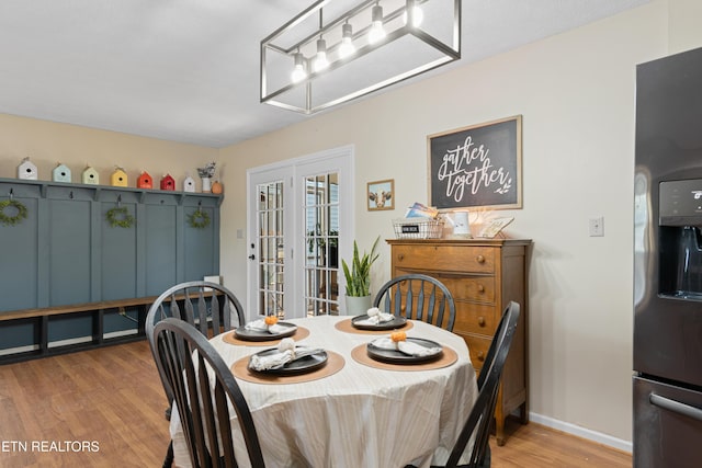 dining area featuring light wood-style flooring, baseboards, and french doors