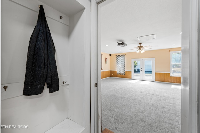 bathroom featuring wooden walls, french doors, and wainscoting