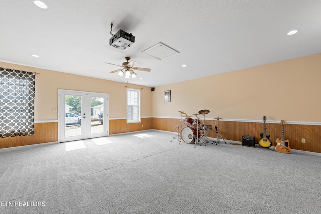 misc room featuring a wainscoted wall, french doors, and wooden walls