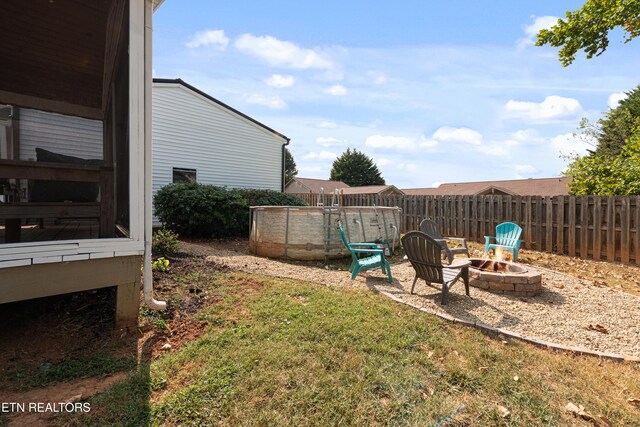 view of yard with fence and a fire pit