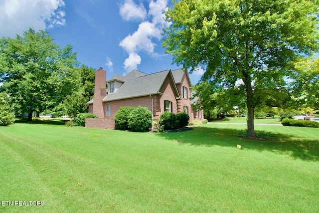 1689 Peppertree Dr, Alcoa, TN 37701 - view of home's exterior featuring brick siding, a chimney, and a yard
