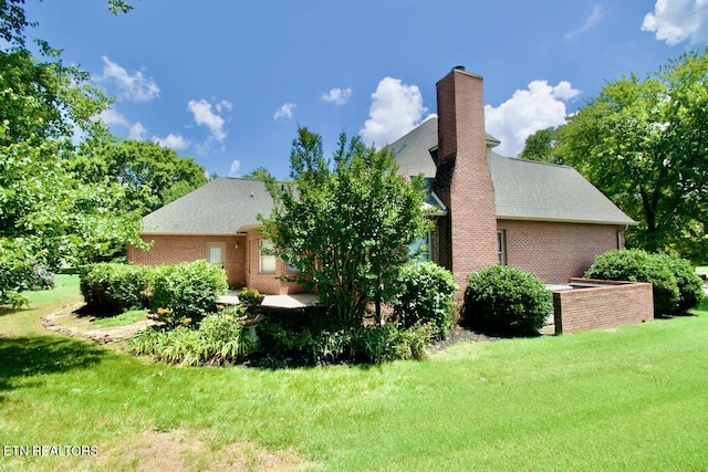 1689 Peppertree Dr, Alcoa, TN 37701 - view of side of home featuring a yard, brick siding, a chimney, and a shingled roof