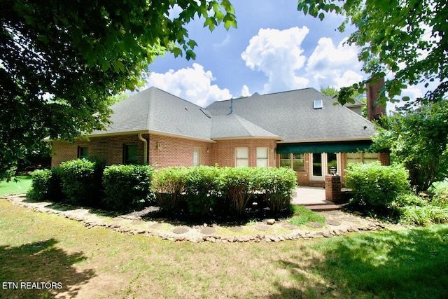 1689 Peppertree Dr, Alcoa, TN 37701 - back of house featuring brick siding, a yard, a chimney, and a patio