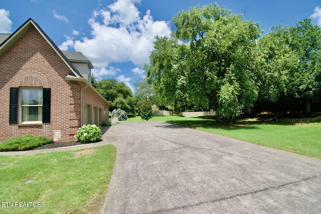 1689 Peppertree Dr, Alcoa, TN 37701 - view of side of home with brick siding, asphalt driveway, a yard, and an attached garage