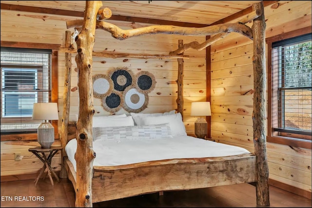 bedroom with wooden ceiling, wooden walls, and wood finished floors