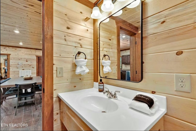 bathroom featuring wood walls, vanity, wood ceiling, and recessed lighting