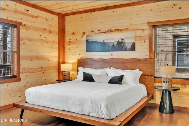 bedroom with wooden ceiling, wooden walls, and wood finished floors