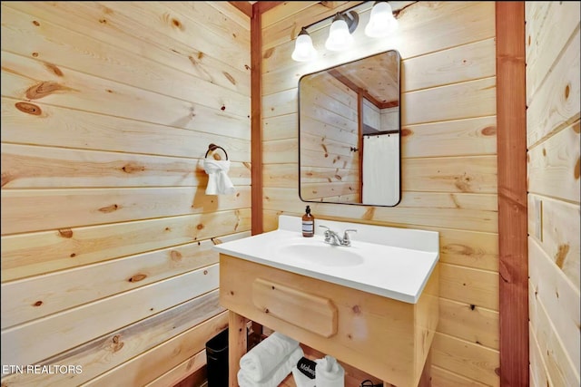 bathroom with wood walls and vanity