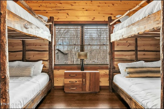 bedroom with wood walls and wood finished floors