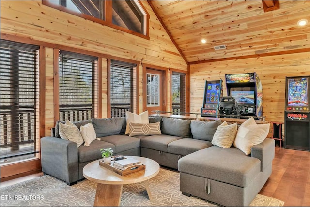 living area with high vaulted ceiling, wooden ceiling, wood finished floors, and wooden walls