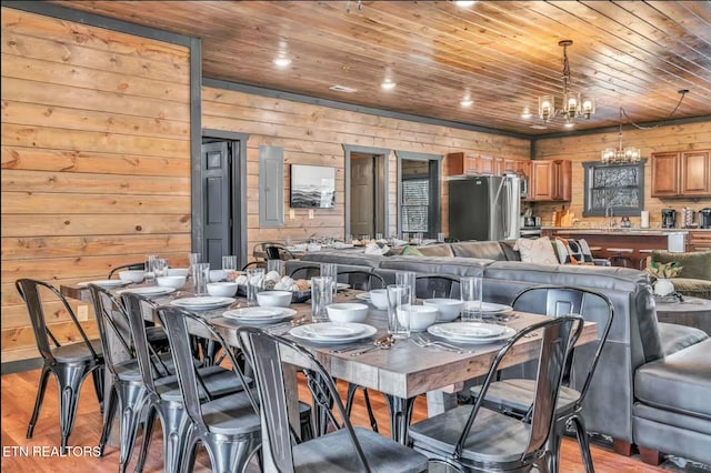 dining room featuring light wood-type flooring, wooden ceiling, and an inviting chandelier