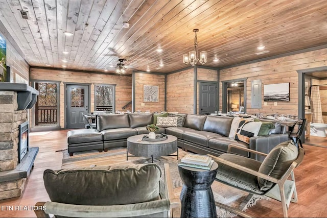 living room featuring wooden ceiling, recessed lighting, wood finished floors, and a stone fireplace