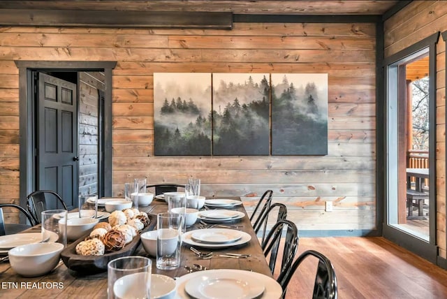 unfurnished dining area with wood walls and wood finished floors