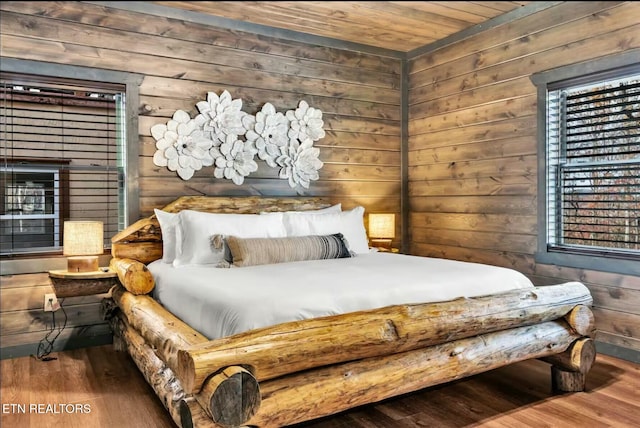 bedroom with wooden ceiling, wooden walls, and wood finished floors