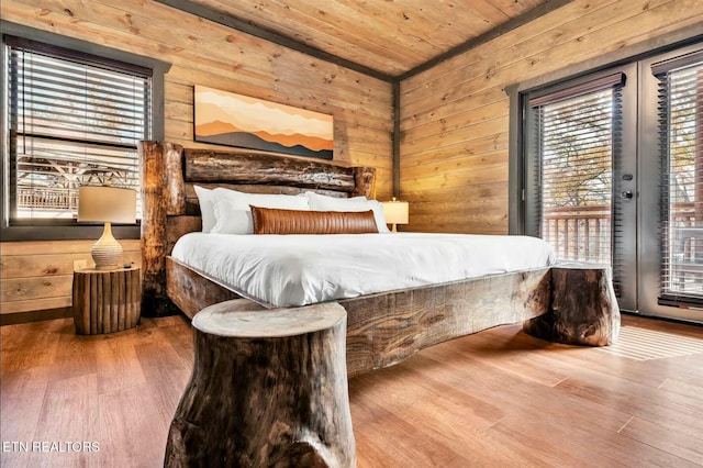 bedroom featuring wood walls, multiple windows, wooden ceiling, and access to exterior