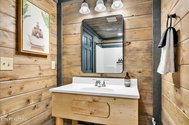 bathroom with vanity and wooden walls