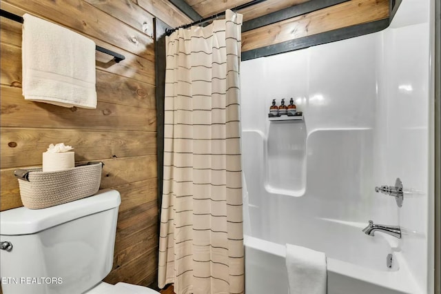 bathroom with shower / tub combo, wooden walls, and toilet