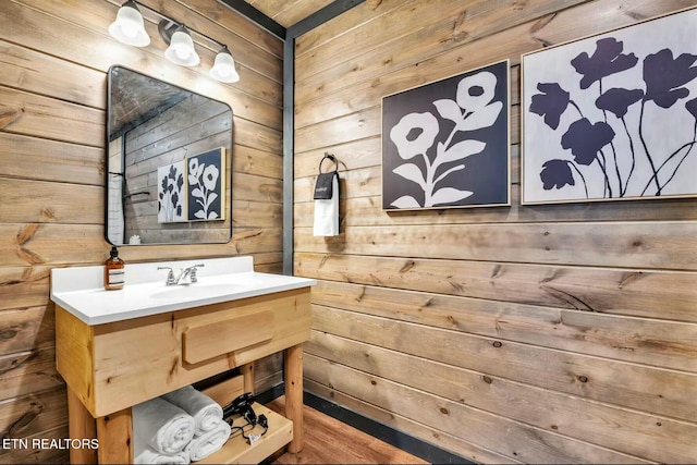 bathroom featuring wooden walls and vanity