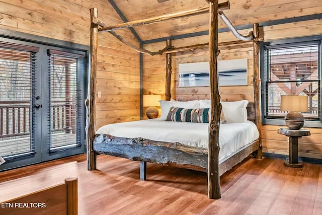 bedroom with lofted ceiling, wooden ceiling, wood finished floors, access to exterior, and wood walls