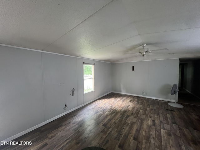 unfurnished living room featuring a textured ceiling, wood finished floors, baseboards, vaulted ceiling, and crown molding