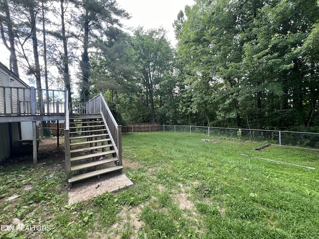 view of yard featuring a fenced backyard, stairs, and a wooden deck