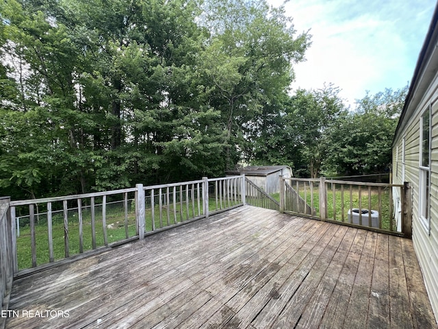 deck with an outbuilding, a yard, and a storage unit