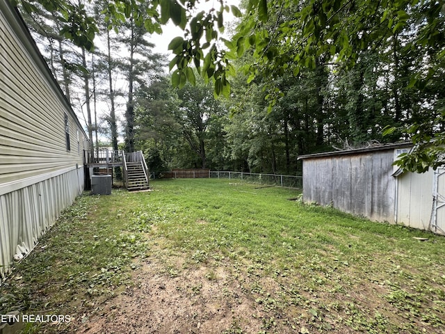 view of yard with stairway, fence, central AC, and a wooden deck