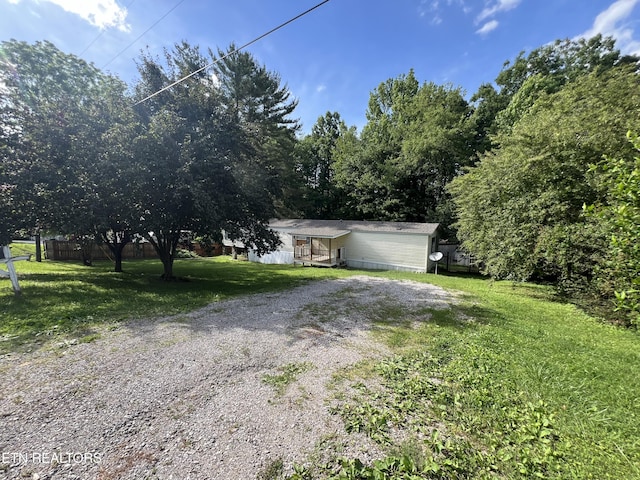 obstructed view of property featuring driveway and a front lawn