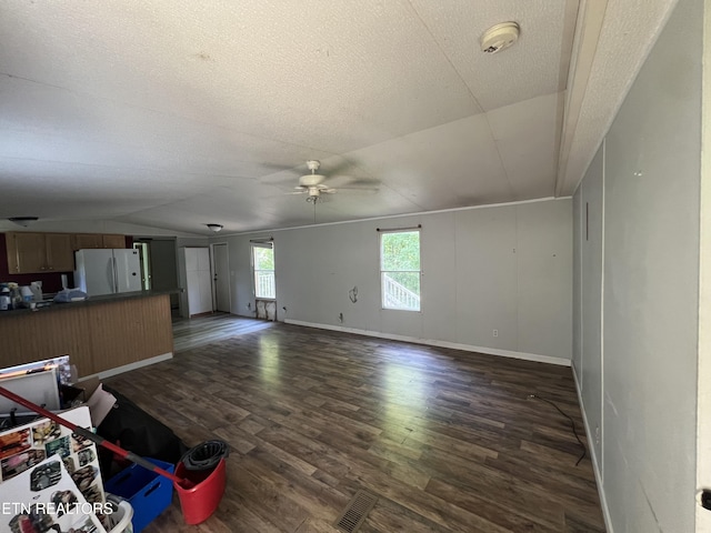 unfurnished living room with dark wood-style floors, a textured ceiling, baseboards, and a ceiling fan