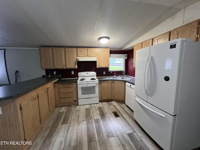 kitchen featuring dark countertops, light wood-style flooring, a textured ceiling, white appliances, and under cabinet range hood