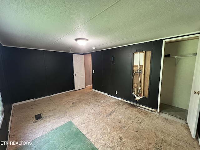 unfurnished bedroom with a textured ceiling and a closet