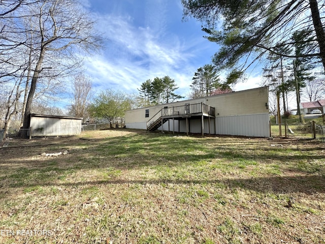 view of yard with a deck, stairs, and fence