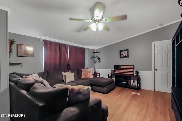 living room with ornamental molding, lofted ceiling, a ceiling fan, and wood finished floors