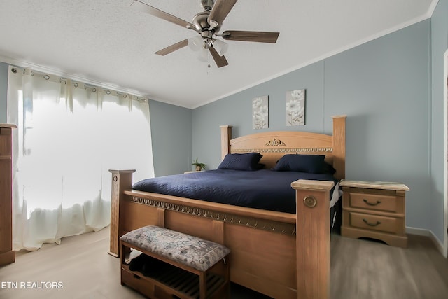 bedroom featuring lofted ceiling, ceiling fan, ornamental molding, wood finished floors, and a textured ceiling