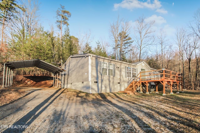 view of outbuilding featuring stairs, driveway, and a detached carport