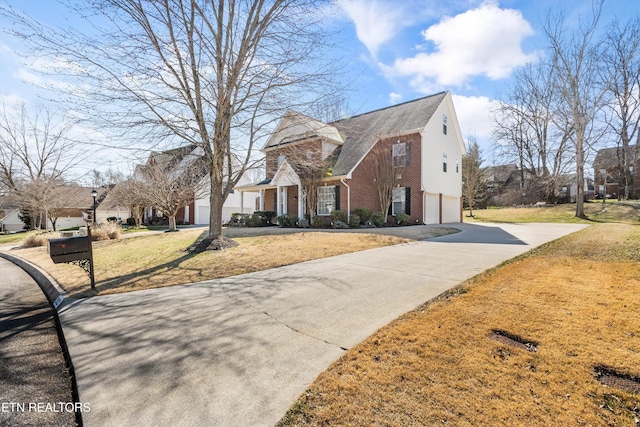 view of front of house with a garage, driveway, brick siding, and a front yard