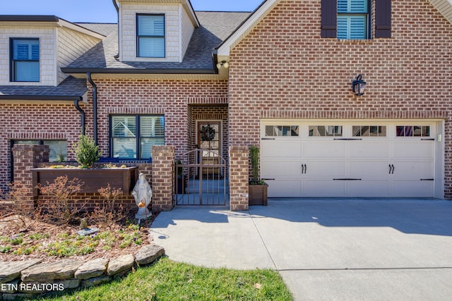 view of front of property with a shingled roof, concrete driveway, and brick siding