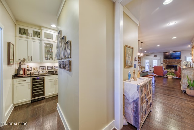 hall with dark wood-type flooring, wine cooler, baseboards, and recessed lighting