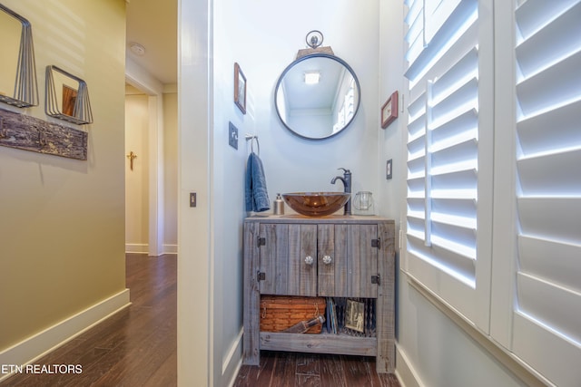 bathroom with vanity, baseboards, and wood finished floors