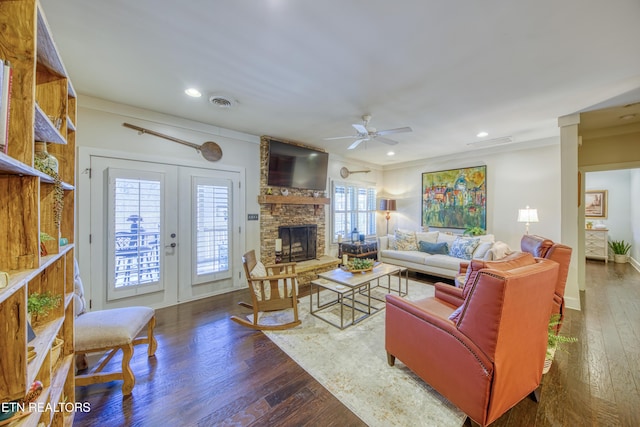 living room featuring ceiling fan, a stone fireplace, recessed lighting, dark wood-style flooring, and visible vents